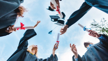 Group of grads tossing hat
